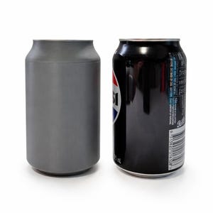 May include: A grey can cooler stands beside a black Pepsi can. The Pepsi can features the red, white, and blue Pepsi logo. The can cooler is designed to keep drinks cool. The Pepsi can has a label with nutritional information and a barcode.