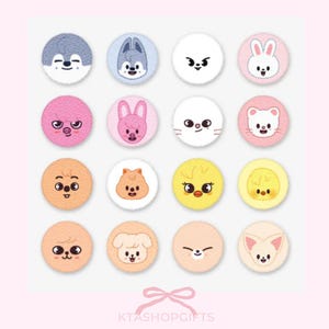 May include: A collection of sixteen round, plush-like patches, each featuring a different cartoon animal face. The patches are in various colors, including pink, white, yellow, and orange, with detailed embroidered facial features. The background is a soft pink.