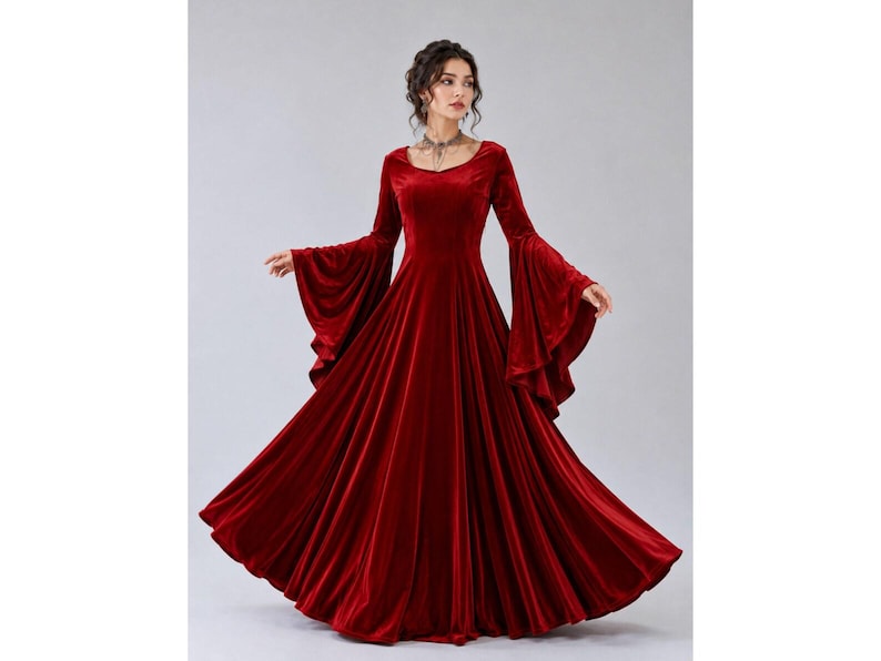 Woman wearing a crimson velvet maxi dress with dramatic bell sleeves and a flowing medieval fantasy silhouette