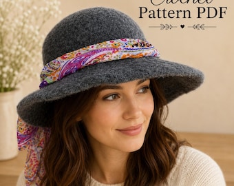 May include: A dark gray felted cloche hat with a wide brim, adorned with a colorful floral and paisley patterned fabric scarf tied around the crown. The text Crochet Pattern PDF is visible in the upper right corner of the image.