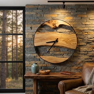 Può includere: Un grande orologio da parete circolare con un quadrante in legno naturale a bordo vivo con venature prominenti, racchiuso in una sottile cornice di metallo nero. L'orologio presenta due semplici lancette nere al centro.