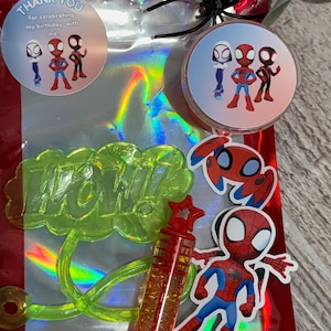 May include: A red cellophane bag with a holographic interior, featuring Spider-Man themed party favors. Includes stickers, a bubble wand, and a green "WOW!" speech bubble. The bag has a black spider decoration.