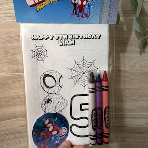 Peut inclure: Un ensemble de coloriage sur le thème de l'anniversaire avec des personnages de Spider-Man. L'ensemble comprend une page à colorier avec le texte "HAPPY 5TH BIRTHDAY LIAM", un autocollant et trois crayons noir, violet et rouge. L'emballage porte le texte "LIAM AMAZING FRIENDS".