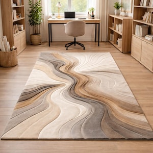 May include: A rectangular area rug featuring a flowing, wave-like pattern in shades of cream, beige, tan, and dark brown. The design consists of carved, multi-level textures that create a sense of depth and movement across the surface of the rug.