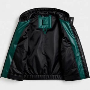 May include: Black jacket with a hood and green trim. The interior is black with a green patch featuring the letter "L". The jacket has two pockets and a zipper closure. The jacket is made of a smooth, possibly leather-like material.