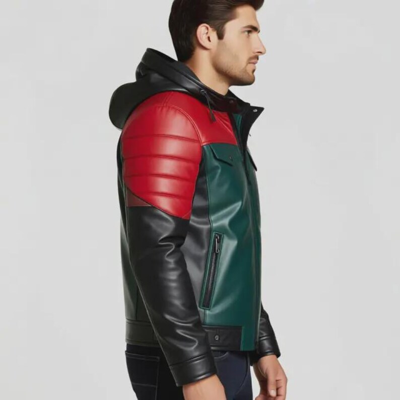 May include: A multi-coloured leather jacket with a hood. The jacket features a red shoulder panel, a green torso, and black sleeves. It has a zip closure and a small pocket on the chest.