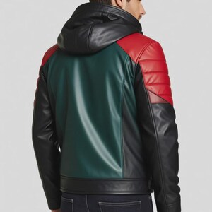 May include: A multi-coloured leather jacket with a black hood and a green back panel. The shoulders are red with quilted stitching. The jacket has a black front and sleeves. The model is wearing dark blue jeans.