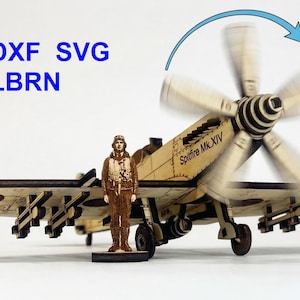 May include: A wooden model of a Spitfire Mk.XIV airplane with a spinning propeller. A small figure of a pilot stands next to the plane. The text "NC DXF SVG AI LBRN" is in the upper left corner.