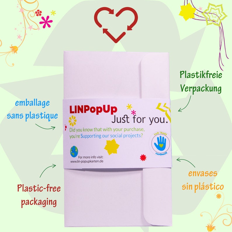 May include: A white envelope with a pink band that says "LINPopUp Just for you." The band also includes a small globe, a yellow star, and a red star. The text "Did you know that with your purchase, you're supporting our social projects?" is printed on the band. The envelope is labeled "Plastic-free packaging" and "Plastikfreie Verpackung".