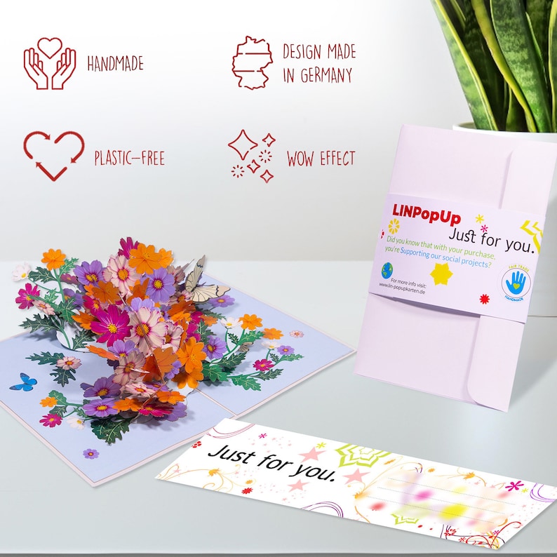 Peut inclure: Une carte pop-up 3D avec un bouquet de fleurs color&eacute;es. La carte est ouverte et les fleurs sortent. La carte est sur une surface blanche. La carte a un message qui dit "Just for you." La carte est fabriqu&eacute;e par LINPopUp et soutient des projets sociaux.