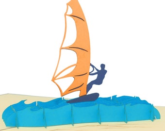 May include: A 3D pop-up card featuring a person windsurfing on a blue wave. The sail is orange and white.