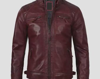 Puede incluir: Chaqueta de cuero burdeos con cuello alzado, cierre de cremallera y múltiples bolsillos. La chaqueta presenta detalles acolchados en los hombros y puños ajustables. El diseño es elegante y moderno, adecuado para diversas ocasiones.