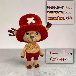 Könnte beinhalten: Eine handgefertigte Häkelfigur von Tony Tony Chopper aus der Anime-Serie One Piece. Die Figur hat einen roten Hut mit weißem Kreuz, braune Geweihe und rote Shorts. Der Text "Tony Tony Chopper" ist sichtbar.