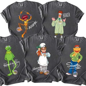 Puede incluir: Cinco camisetas de color gris oscuro con personajes de los Muppets: Animal, Beaker, Kermit la Rana, el Chef Sueco y Scooter. Cada camiseta muestra un gráfico colorido del personaje con su nombre. Las camisetas tienen un aspecto vintage y desgastado.