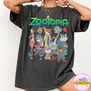 Pu&ograve; includere: T-shirt Zootopia grigio scuro con una grafica colorata dei personaggi del film d'animazione. Il testo "Zootopia" &egrave; in verde e blu. La maglietta &egrave; realizzata in un materiale morbido.