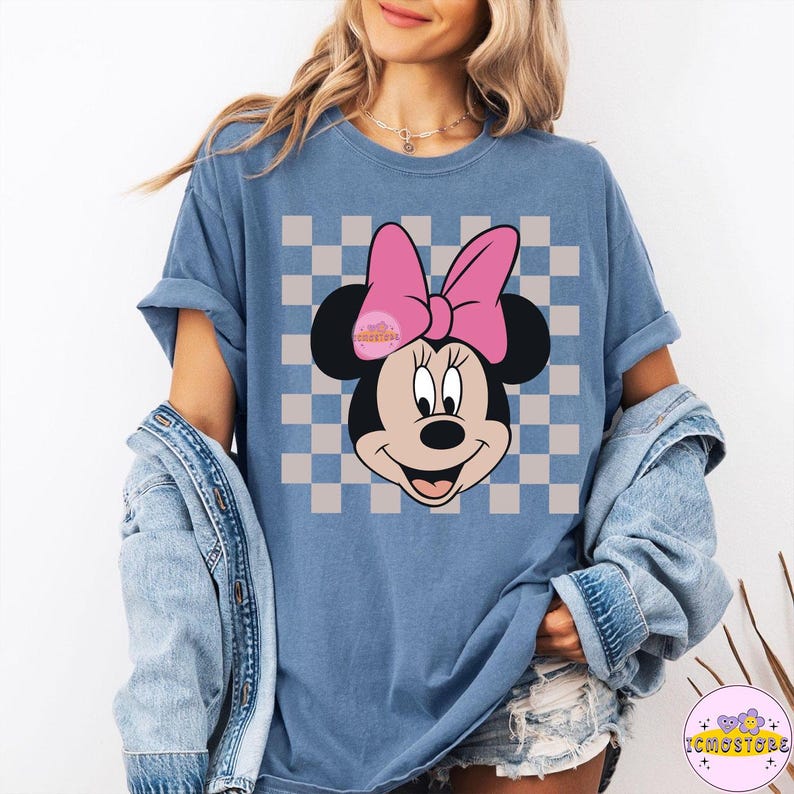 Puede incluir: Camiseta azul con un dise&ntilde;o de Minnie Mouse, un lazo rosa y un fondo a cuadros. El dise&ntilde;o incluye el texto "Wonderful". Forma parte de una colecci&oacute;n de ropa.