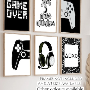 May include: Six framed art prints with a gaming theme. The prints feature game controllers, headphones, and text like "GAME OVER" and "Just 5 more minutes." The color scheme is mainly black, white, and olive green.