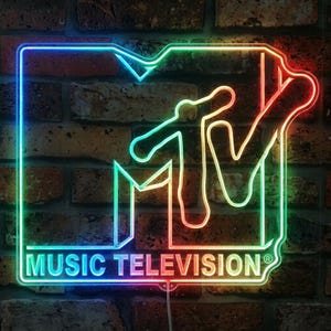May include: A rectangular neon sign featuring the MTV logo with the text MUSIC TELEVISION in a gradient of blue, green, yellow, and red light. The sign is outlined in a glowing neon tube, creating a vibrant display of the iconic music brand logo.