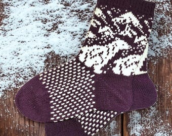 May include: A pair of dark purple socks with a white geometric pattern. The socks have a textured design on the foot and heel, and a patterned design on the upper part. The socks are made of a warm material, perfect for cold weather.
