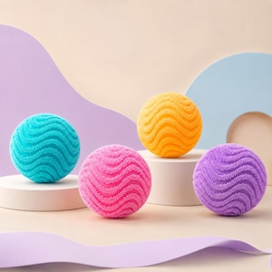 May include: Four spherical laundry dryer balls with a textured, wavy surface pattern. The set includes one bright turquoise ball, one vibrant pink ball, one golden yellow ball, and one light purple ball, each resting on a small white circular stand.