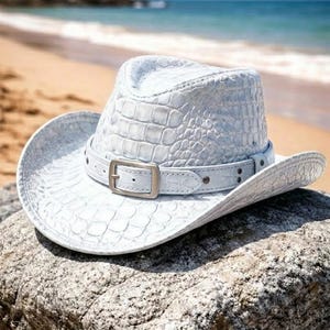 Può includere: Una tazza di ceramica bianca con un manico nero e la scritta "But First, Coffee" in stile scritto a mano. La tazza è su una superficie bianca. La tazza è alta circa 10 cm.