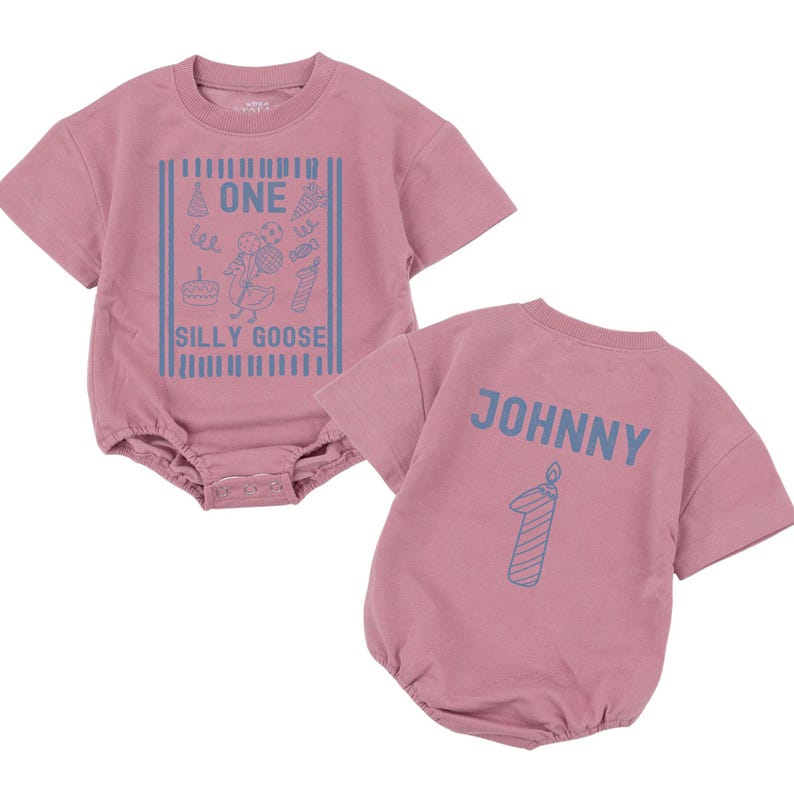 May include: A dusty rose short-sleeved romper featuring a blue graphic print on the front with a goose, party elements, and the text ONE SILLY GOOSE. The back displays the name JOHNNY in blue letters above a blue graphic of a number one candle.