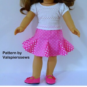 May include: A pink and white polka dot skirt with a white crocheted top. The outfit is for a doll. Pattern by Valspierressews.