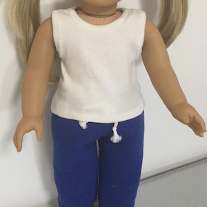 May include: A white sleeveless shirt and blue sweatpants for a doll.