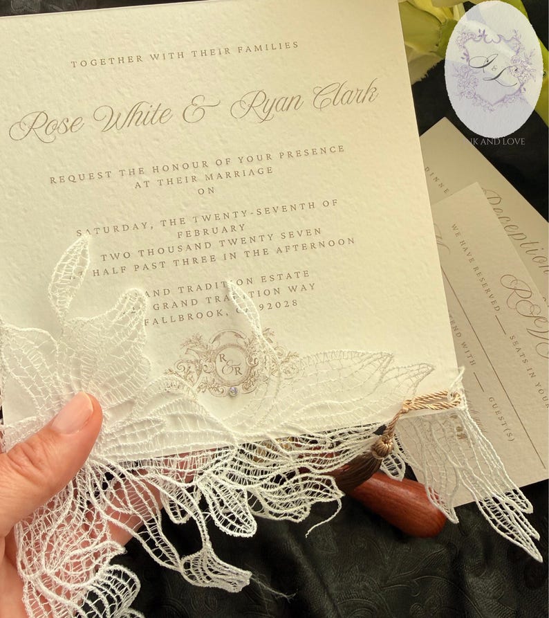 Puede incluir: Invitaci&oacute;n de boda marfil con escritura elegante, con los nombres Rose White & Ryan Clark. La invitaci&oacute;n incluye un delicado adorno de encaje y una borla de madera. Se ven tarjetas de confirmaci&oacute;n de asistencia y recepci&oacute;n adicionales.