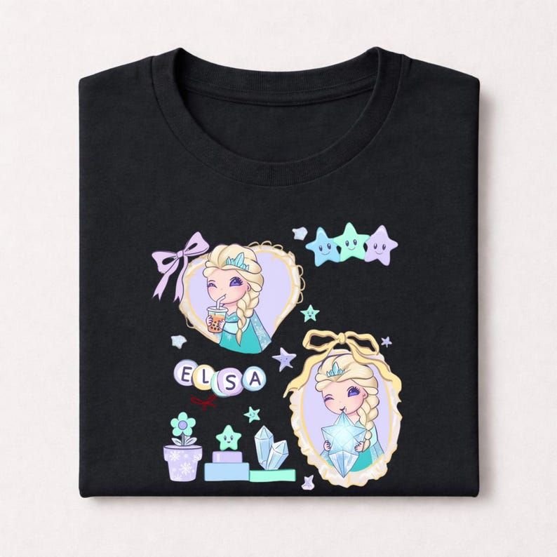 May include: Black t-shirt with a cartoon illustration of a character with blonde braids, wearing a crown, and holding a star. The design includes the name "ELSA" and decorative elements like stars, bows, and a flower pot.