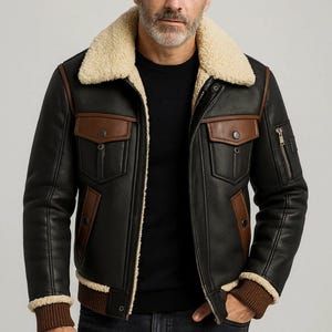 May include: Black leather jacket with a shearling collar and brown detailing. The jacket has two front pockets, a zipped chest pocket, and ribbed cuffs. A stylish outerwear piece.