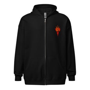 Puede incluir: Sudadera negra con cremallera, capucha y bolsillos delanteros. Un diseño de llama roja y naranja está bordado en el pecho izquierdo. La sudadera tiene una cremallera completa y un aspecto suave y cómodo.