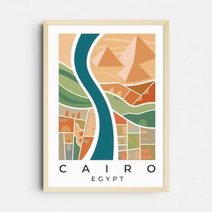 May include: Framed art print featuring a stylized illustration of Cairo, Egypt. The artwork depicts the Nile River, pyramids, and city blocks in shades of orange, green, and blue. The word "CAIRO" and "EGYPT" are printed at the bottom.