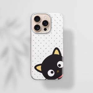 Op de afbeelding: Een witte iPhone-hoes met een zwart kattenstripontwerp. De hoes heeft een stippenpatroon en een transparante rand. De kat heeft gele oren en een roze tong. De telefoonhoes is ontworpen om de telefoon te beschermen tegen krassen en beschadigingen.