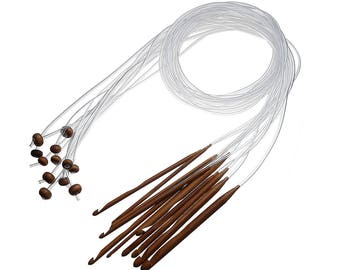 Peut inclure: Un ensemble d'aiguilles à tricoter circulaires avec des crochets en bois brun et des câbles en plastique transparent. Les aiguilles sont disposées en éventail, les crochets pointant vers l'extérieur. Plusieurs tailles d'aiguilles sont incluses.