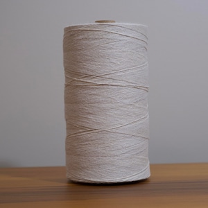 May include: A spool of natural white cotton thread.