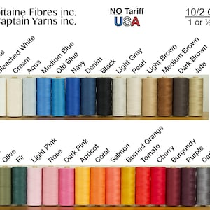Może przedstawiać: Kolekcja szpul nici bawełnianych 10/2 od Capitaine Fibres inc. i Captain Yarns inc. Szpule są ułożone w dw&oacute;ch rzędach, prezentując szeroką gamę kolor&oacute;w, w tym odcienie bieli, niebieskiego, brązu, zieleni, r&oacute;żu, pomarańczu oraz czerwieni.