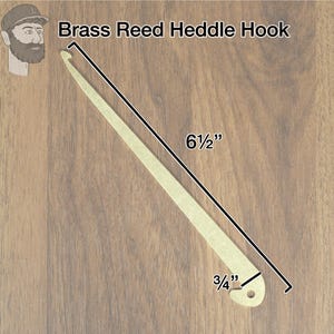 May include: Brass reed heddle hook, 6 1/2 inches long and 3/4 inch wide. The hook is made of brass and has a smooth, polished finish.
