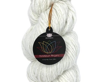 May include: A skein of white handspun angora yarn, naturally sourced from China. The yarn is packaged with a circular tag that reads "Lotus Yarns" and "Handspun Angora" with a colorful lotus flower logo.