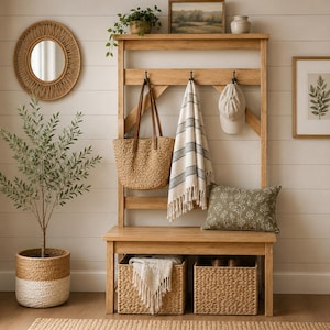 May include: A wooden entryway bench with a shelf, hooks, and storage baskets. A woven tote bag, striped blanket, and baseball cap hang from the hooks. A round mirror, framed art, and a potted plant complete the decor.
