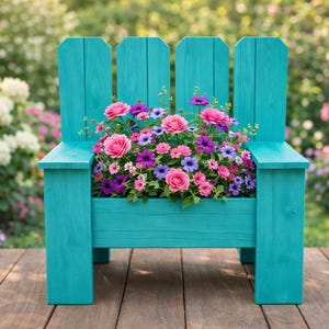 May include: A turquoise wooden chair-shaped planter, filled with pink, purple, and blue flowers. The planter sits on a wooden deck, with a blurred garden in the background.