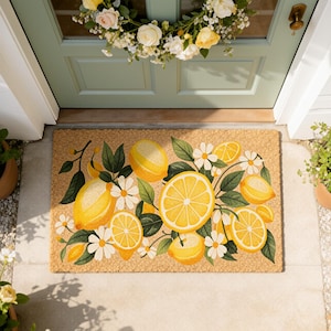 May include: A rectangular doormat made of natural fibers, featuring a vibrant design of lemons, daisies, and green leaves. The lemons are yellow with white accents, and the daisies are white with yellow centers. The mat is placed in front of a light green door.