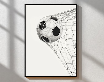 May include: Black and white framed print of a soccer ball in a net. The soccer ball is black and white, and the net is a light gray color. The image is a close-up shot of the ball in the net.