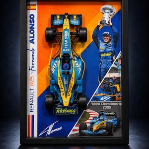 May include: A framed display featuring a scale model of the blue and yellow Renault R25 Formula 1 car, a photograph of Fernando Alonso holding a trophy, and a racing image. The text reads RENAULT R25 Fernando ALONSO and World Championship 2005.