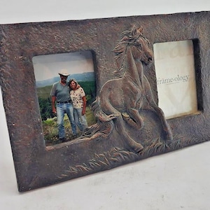 May include: A rectangular brown picture frame with a textured surface. The frame has two openings, one with a photo of a couple and the other with the text "frame-ology". A sculpted horse is on the frame.
