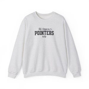 以下が含まれることがあります： 「life happens & POINTERS help」の黒い文字が入った、明るい灰色のスウェットシャツ。スウェットシャツはクルーネックと長袖です。生地はまだら模様です。