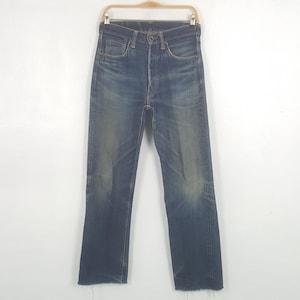 May include: A pair of high-waisted blue denim jeans featuring a faded wash, a button fly closure, and raw, frayed hems at the bottom of the legs. The denim displays natural whiskering patterns at the hips and lighter blue fading at the knees.