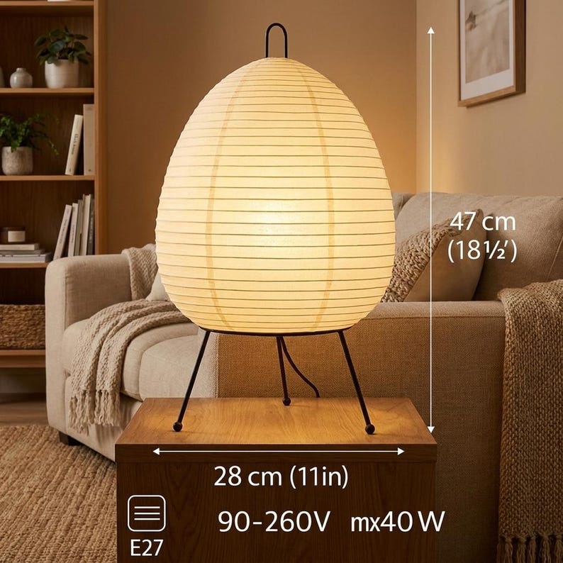 May include: An egg-shaped paper lamp with a black metal frame. The lamp is 18.5 inches tall and 11 inches wide. The lamp has a warm, inviting glow, perfect for a living room or bedroom. The lamp is on a wooden table.
