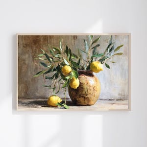 Puede incluir: Pintura enmarcada de naturaleza muerta con un jarrón rústico y texturizado lleno de ramas de olivo y limones amarillos brillantes. La obra de arte tiene una paleta de colores cálidos y neutros, con un enfoque en elementos naturales.