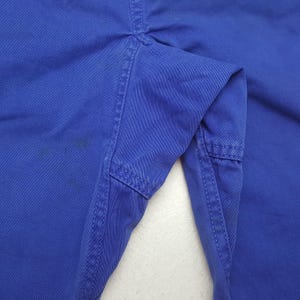 Puede incluir: Primer plano de un pantal&oacute;n azul, mostrando la textura de la tela y los detalles de las costuras. La imagen destaca las costuras y la construcci&oacute;n de la prenda, con enfoque en la zona del bolsillo y el color general.